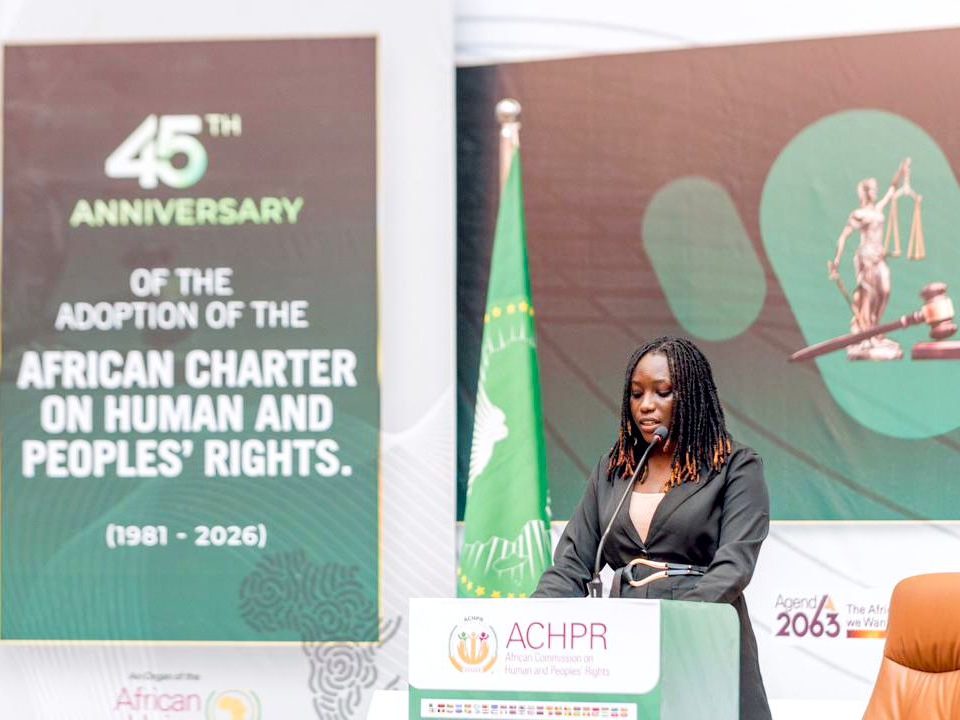 A speaker at the podium beside a banner marking the 45th anniversary of the African Charter on Human and Peoples' Rights